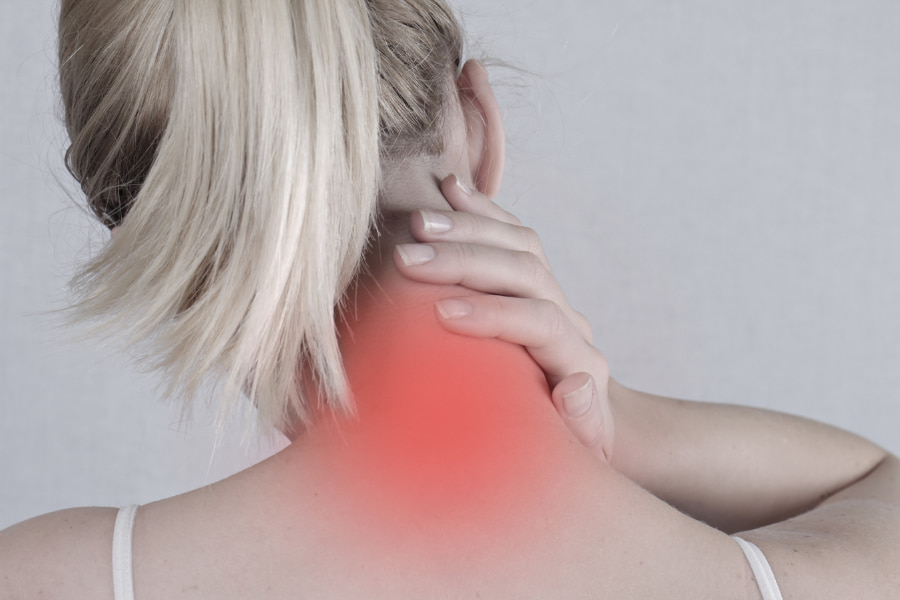 black and white image of a woman experiencing neck pain