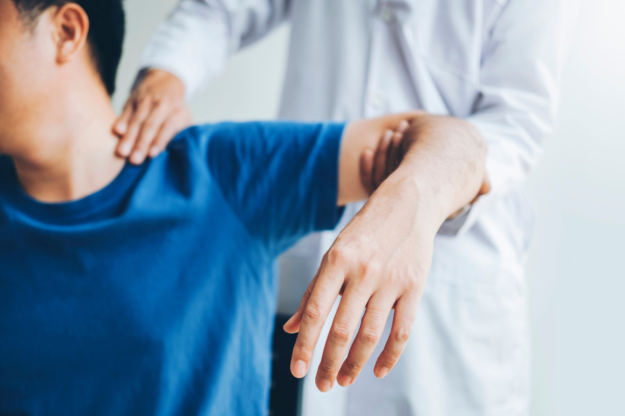 doctor checking a patient's arm and neck pain